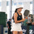 Woman playing pickleball on a court with spectators in the background. In a pickleball bucket hat